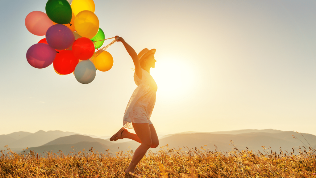 Happy woman running with colourful balloons